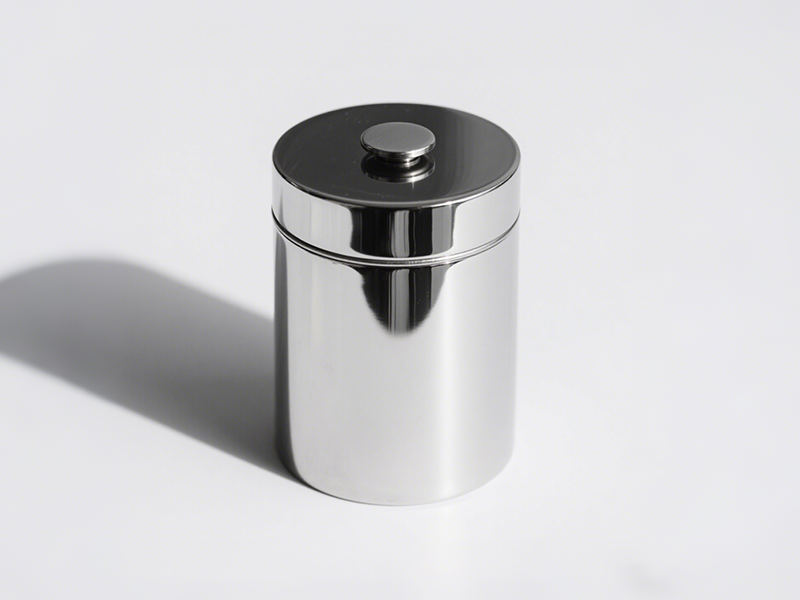 Cylindrical silver jar, with a circular handle on the lid center, shining metallic luster, simple shape with practical ideas.