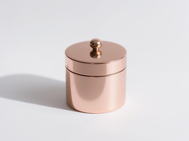 Cylindrical rose gold jar, with a small circular handle on the lid center, soft color, delicate and elegant.