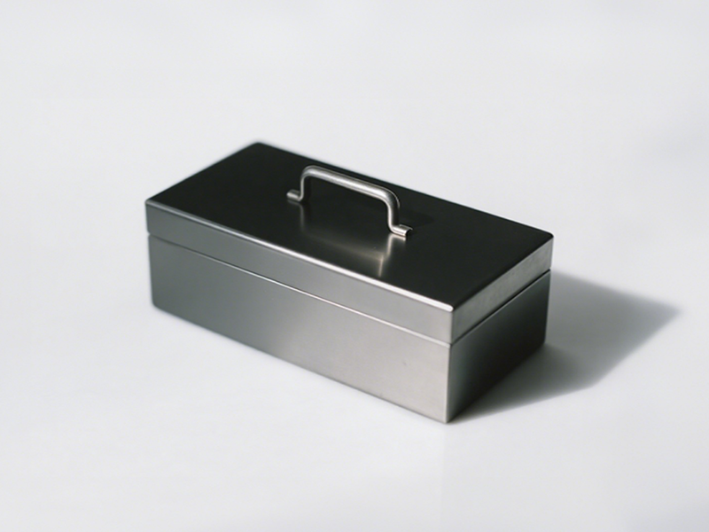 Rectangular gunmetal box, matte surface, with a strip-shaped metal handle in the center of the top, simple and practical.
